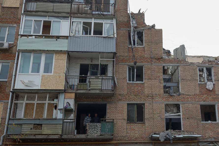 Local resident Tetiana Honcharova and her husband Mykhailo stand inside of their apartment damaged by a recent Russian missile attack in Mykolaiv