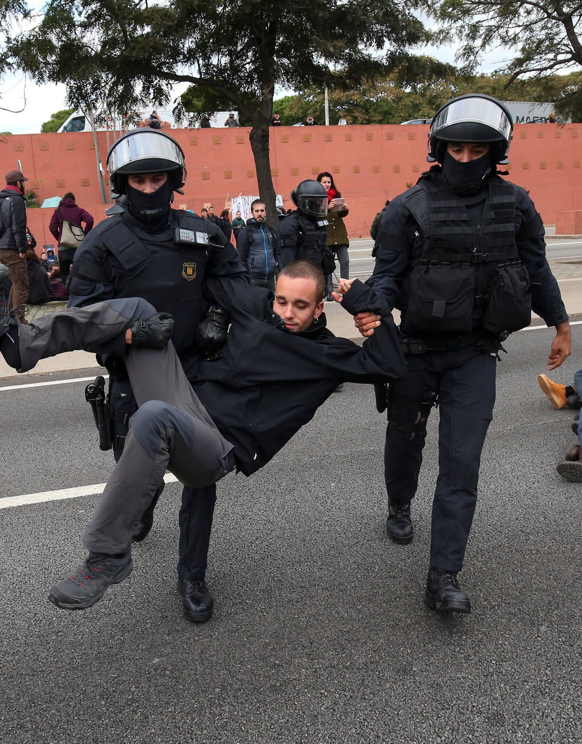 Police remove protestors blocking a ring road in Barcelona during a partial regional strike in Barcelona