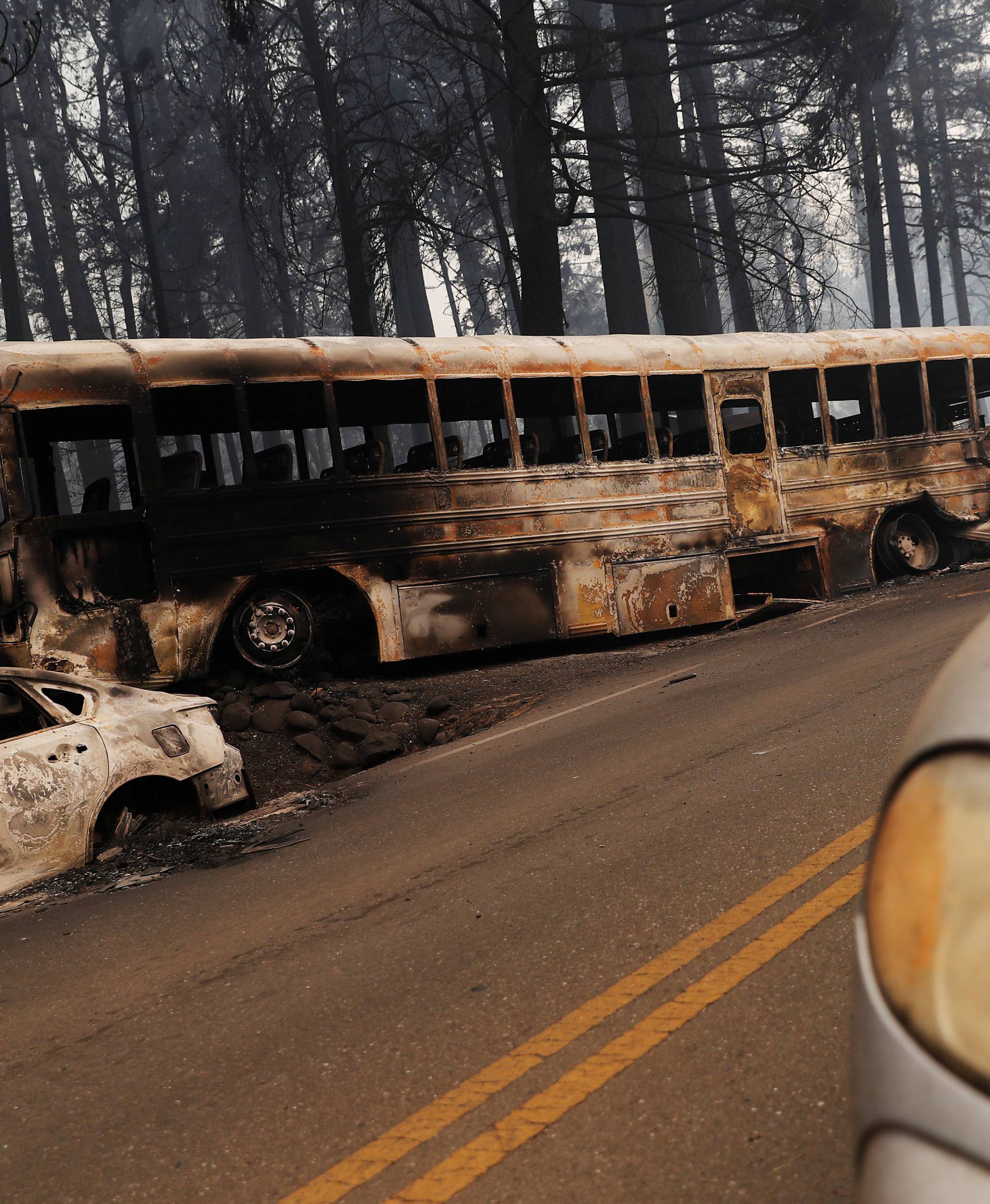 An abandoned and burned school bus is seen on Skyway during the Camp Fire in Paradise