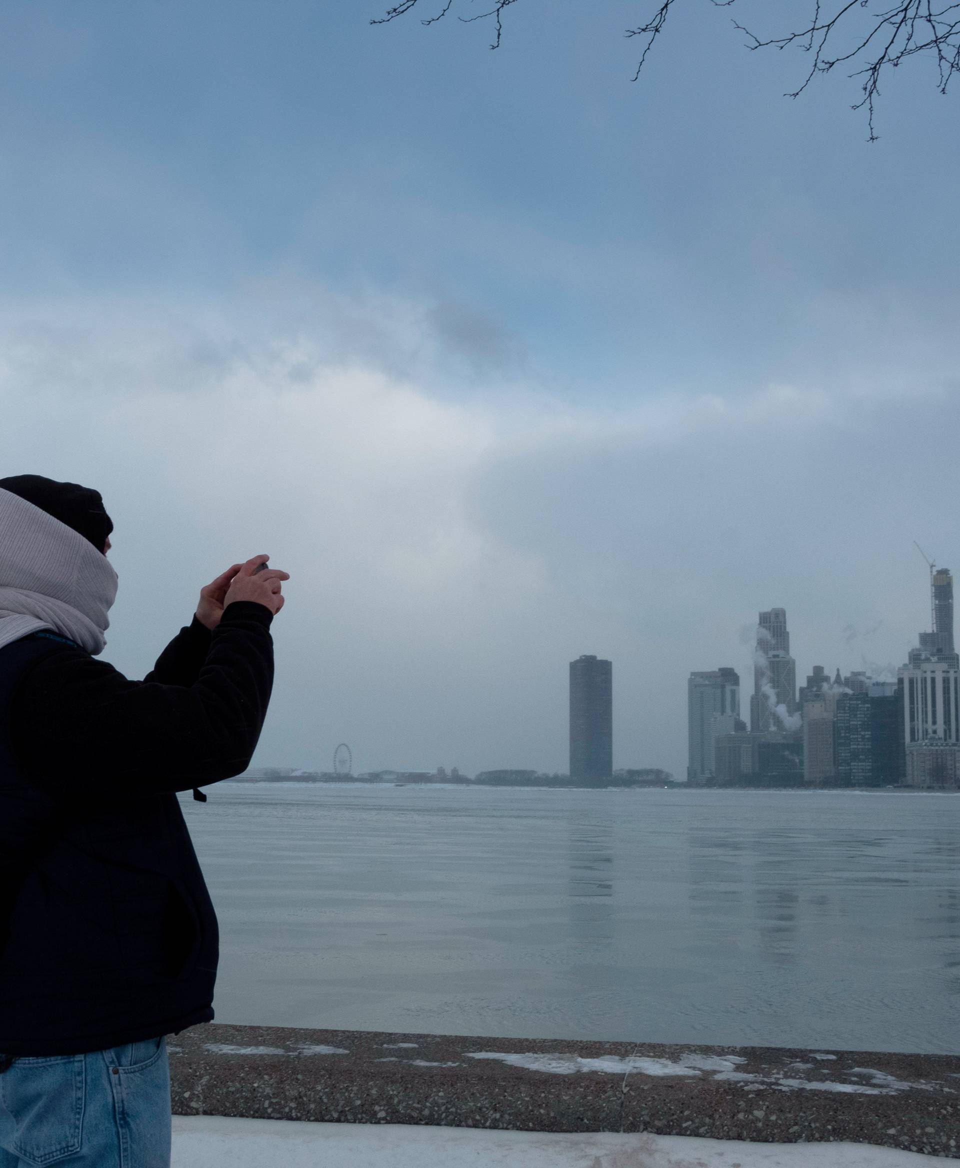 Jim Cleary takes a photo of the city skyline from the North Avenue Beach at Lake Michigan in Chicago