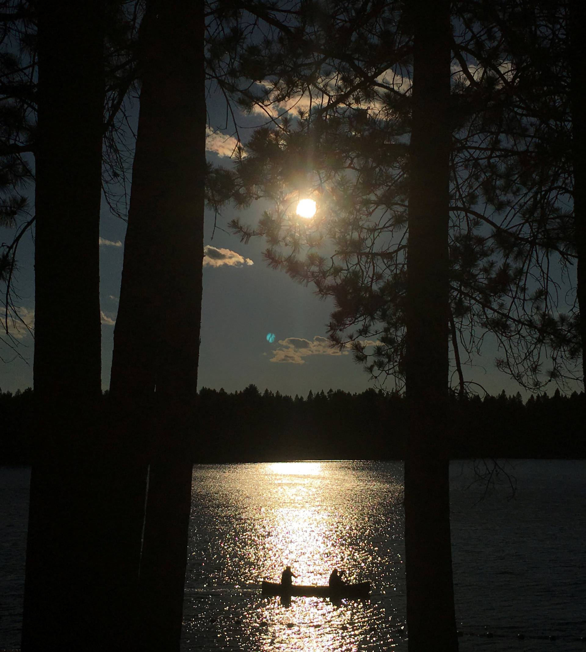 People paddle a canoe at sunset on Pog Lake in Algonquin Park