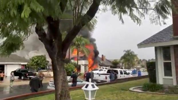 Smoke billows after a plane crashed into a house in a residential neighborhood in Yorba Linda, California