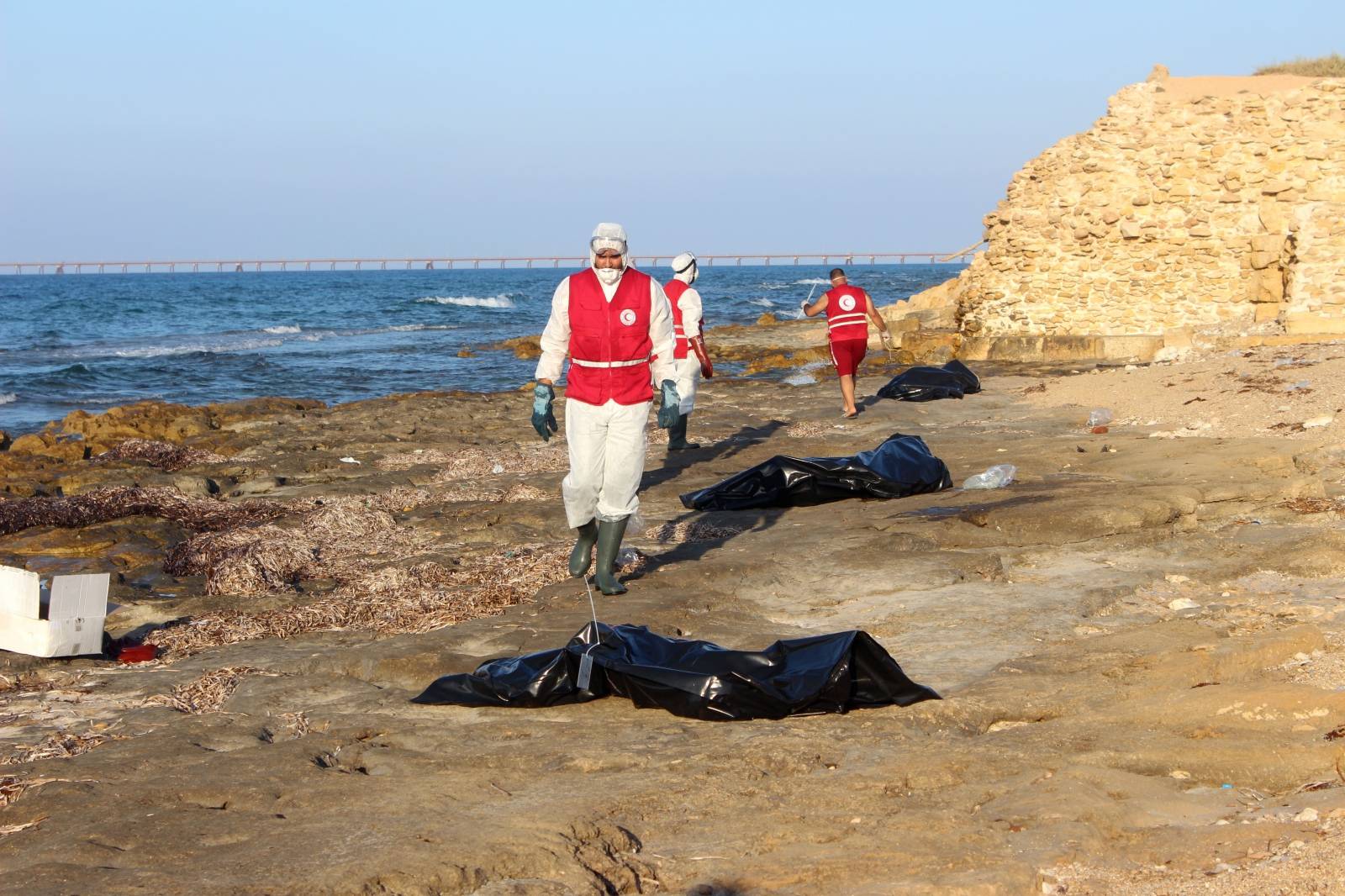 Libyan Red Crescent workers are seen near bags containing bodies of migrants, who died after their wooden boat capsized, in Khoms