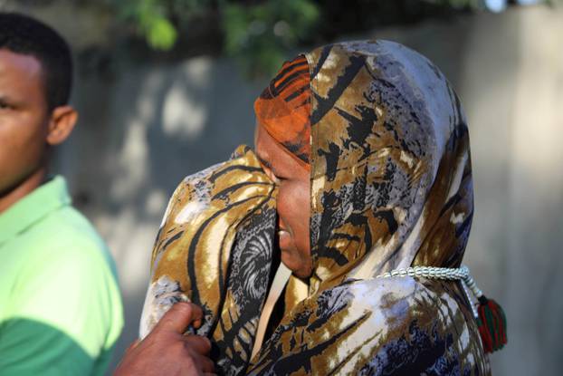 A Somali woman mourns at the scene of a suicide car bomb explosion, at the gate of Naso Hablod Two Hotel in Hamarweyne district of Mogadishu