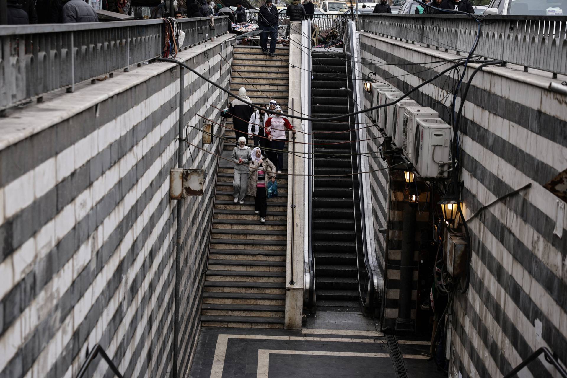 Women walks down the stairs  in downtown of Damascus,