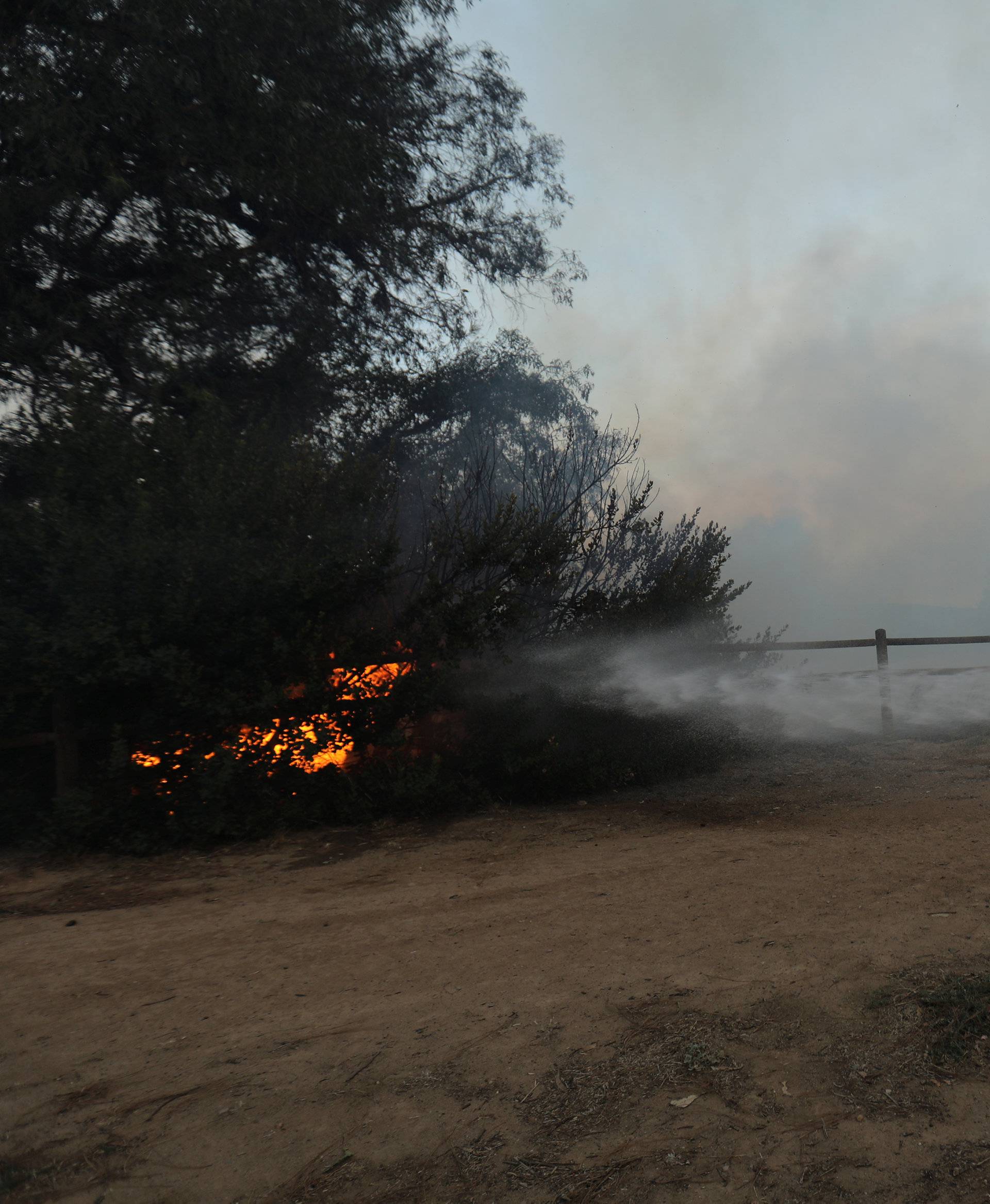 A firefighter battles a fast moving wind driven wildfire in Orange