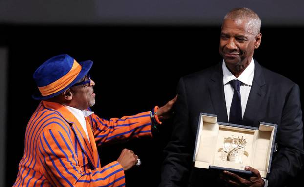 Denzel Washington receives the Honorary Palme d'Or from director Spike Lee, ahead of the screening of the film "Highest 2 Lowest", at the 78th edition of the Cannes Film Festival in Cannes