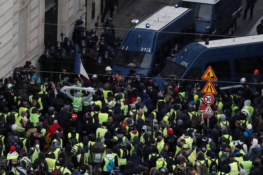 Protesters wearing yellow vests face off with French Gendarmes on the Champs-Elysees Avenue during a demonstration by the "yellow vests" movement in Paris