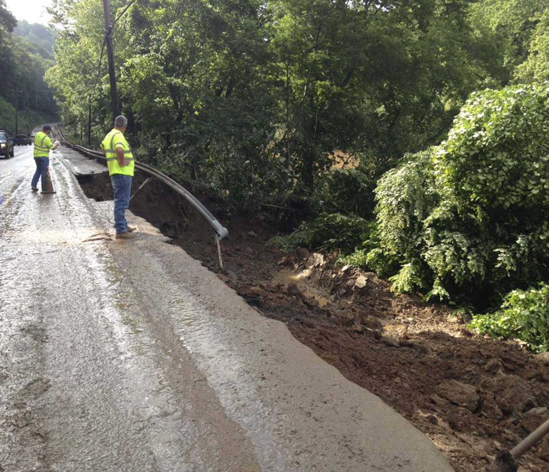 Officials survey the West Virginia State Highway 4 along the Elk River with extensive damages to the road after flood water has dropped in the Clendenin