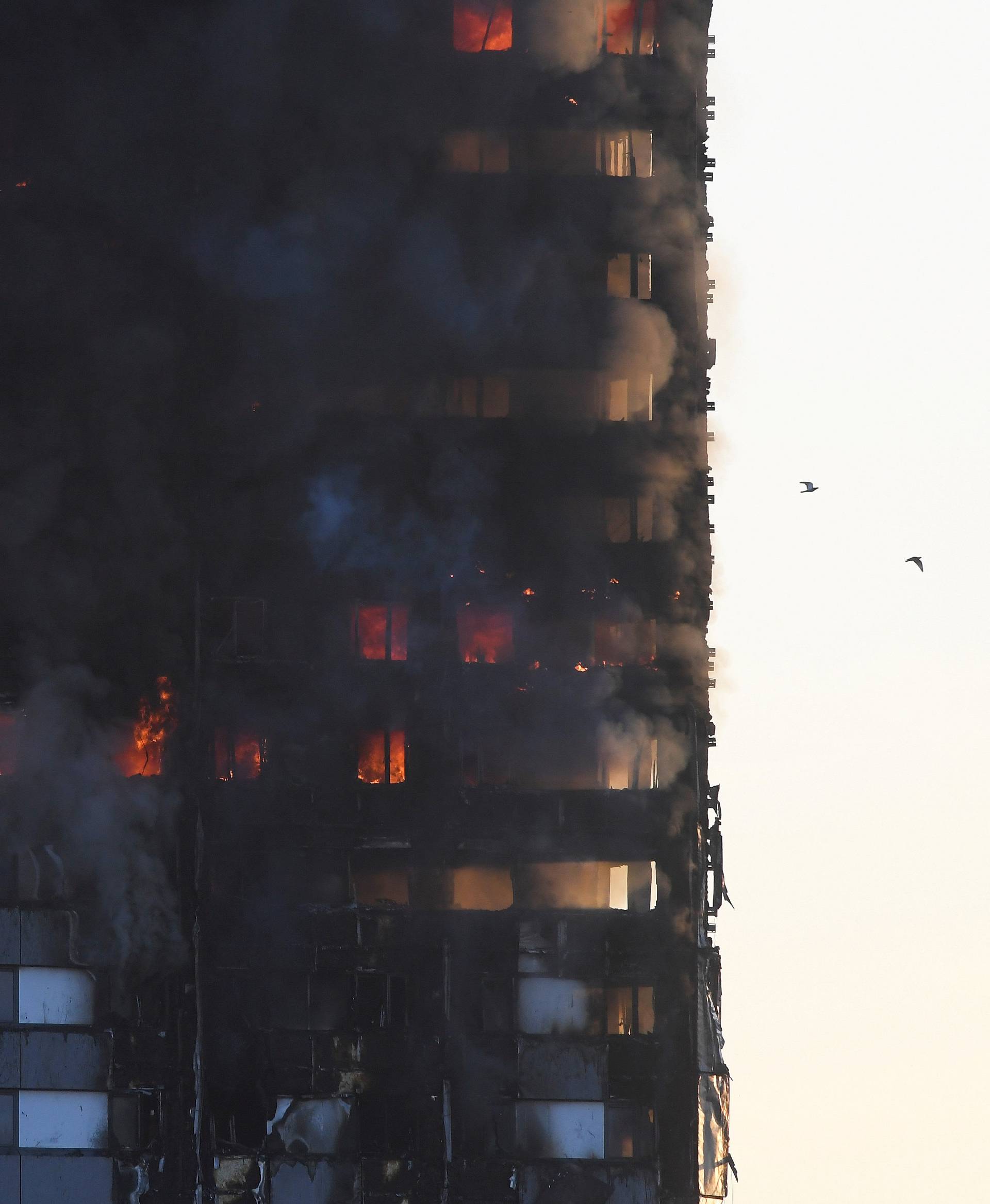 Flames and smoke billow as firefighters deal with a serious fire in a tower block at Latimer Road in West London