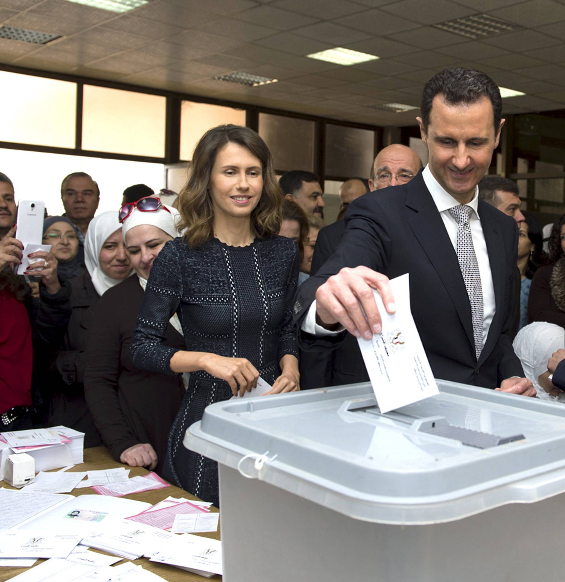 Syria's President Bashar al-Assad casts his vote next to his wife Asma inside a polling station during the parliamentary elections in Damascus