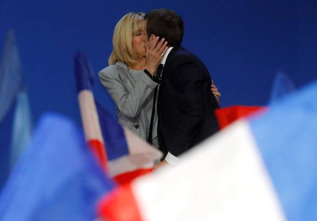 Emmanuel Macron, head of the political movement En Marche !, or Onwards !, and candidate for the 2017 French presidential election, kisses his wife Brigitte Trogneux as he arrives on stage to deliver a speech at the Parc des Expositions hall in Paris