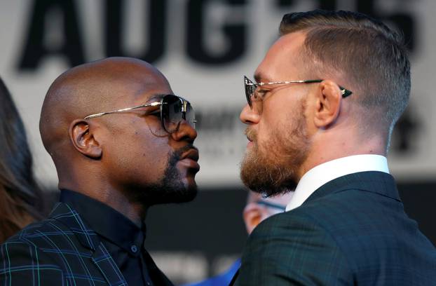 Undefeated boxer Floyd Mayweather Jr. (L) of the U.S. and UFC lightweight champion Conor McGregor of Ireland face off during a news conference in Las Vegas