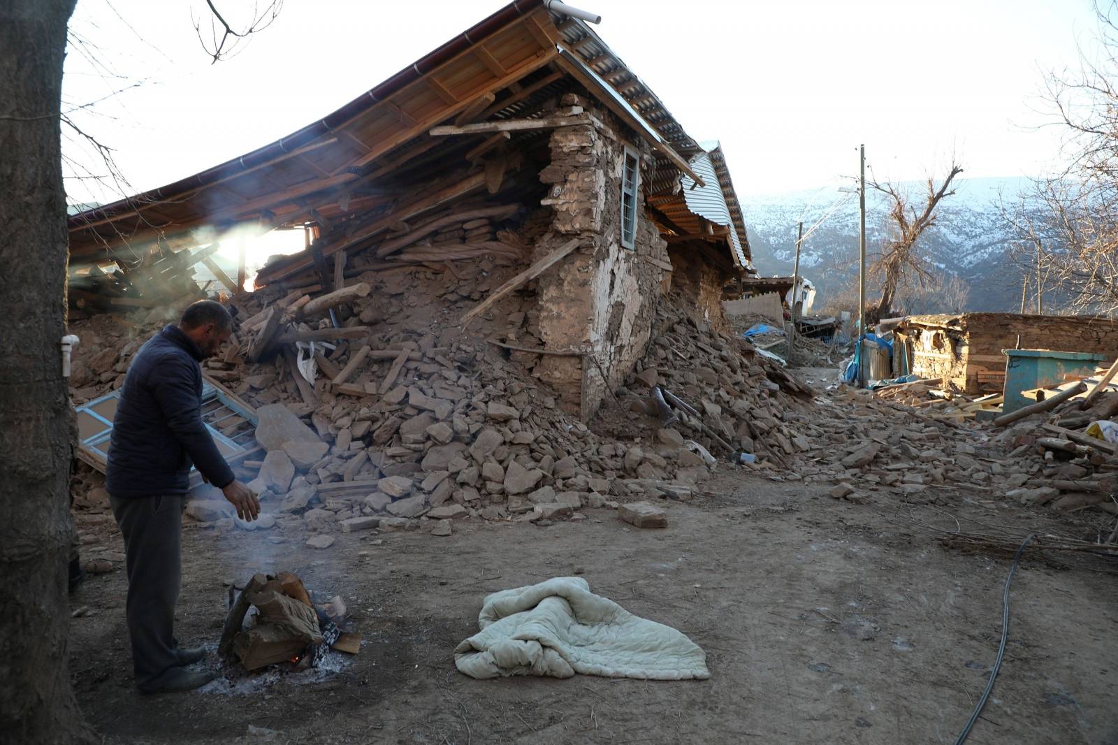 A villager stands next to his collapsed house after an earthquake in Sivrice near Elazig