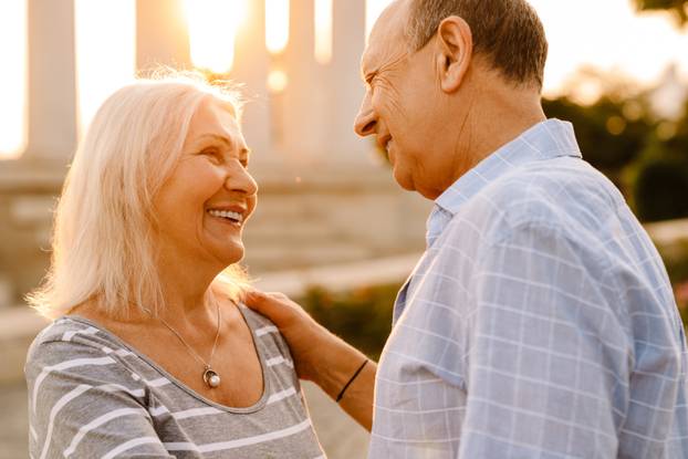 White senior couple hugging and smiling together outdoors
