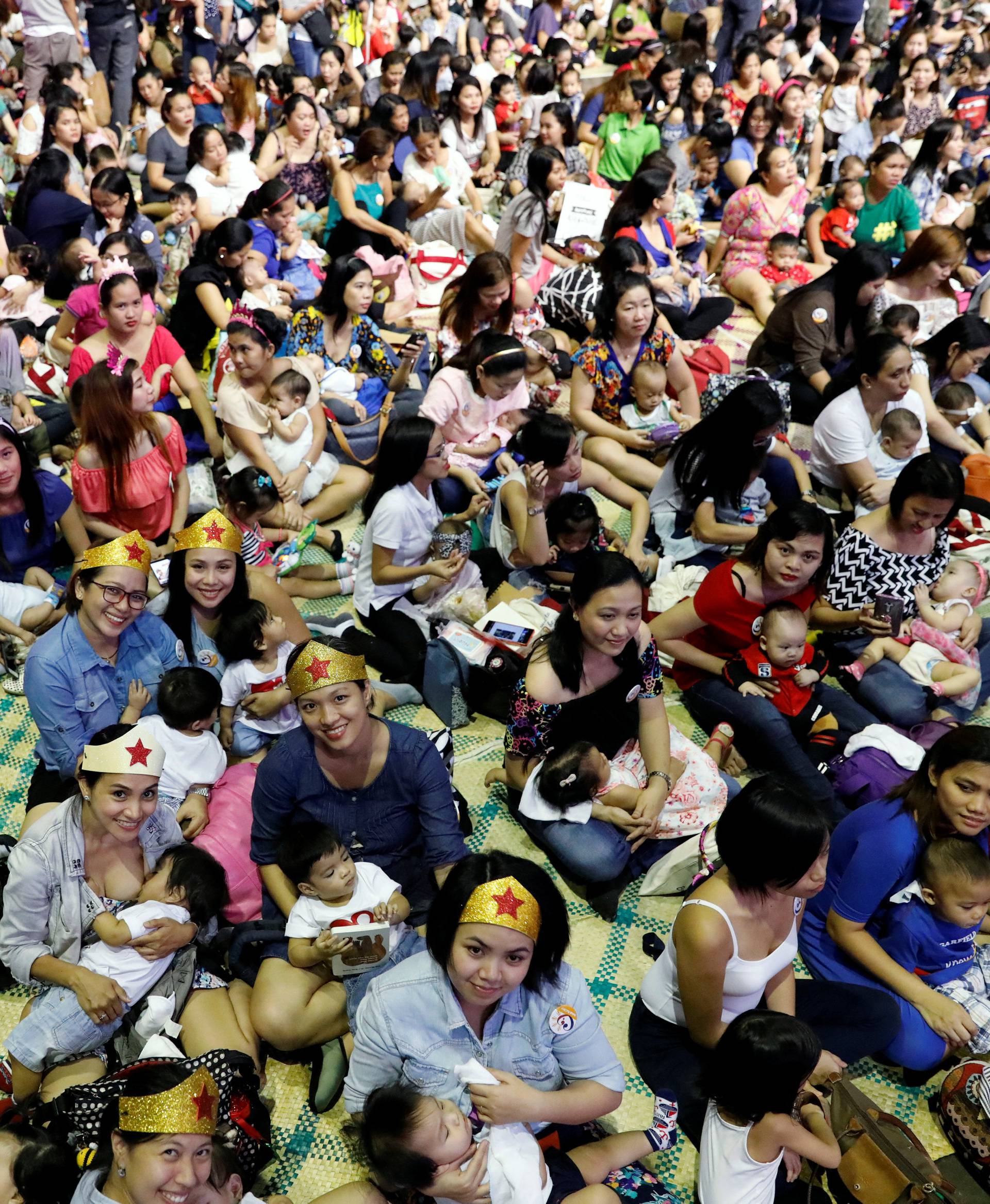 Filipino mothers hold their babies during a one-minute simultaneous breastfeeding event, as a way to promote breastfeeding, on the sidelines of this year's ASEAN foreign ministers summit, in Manila