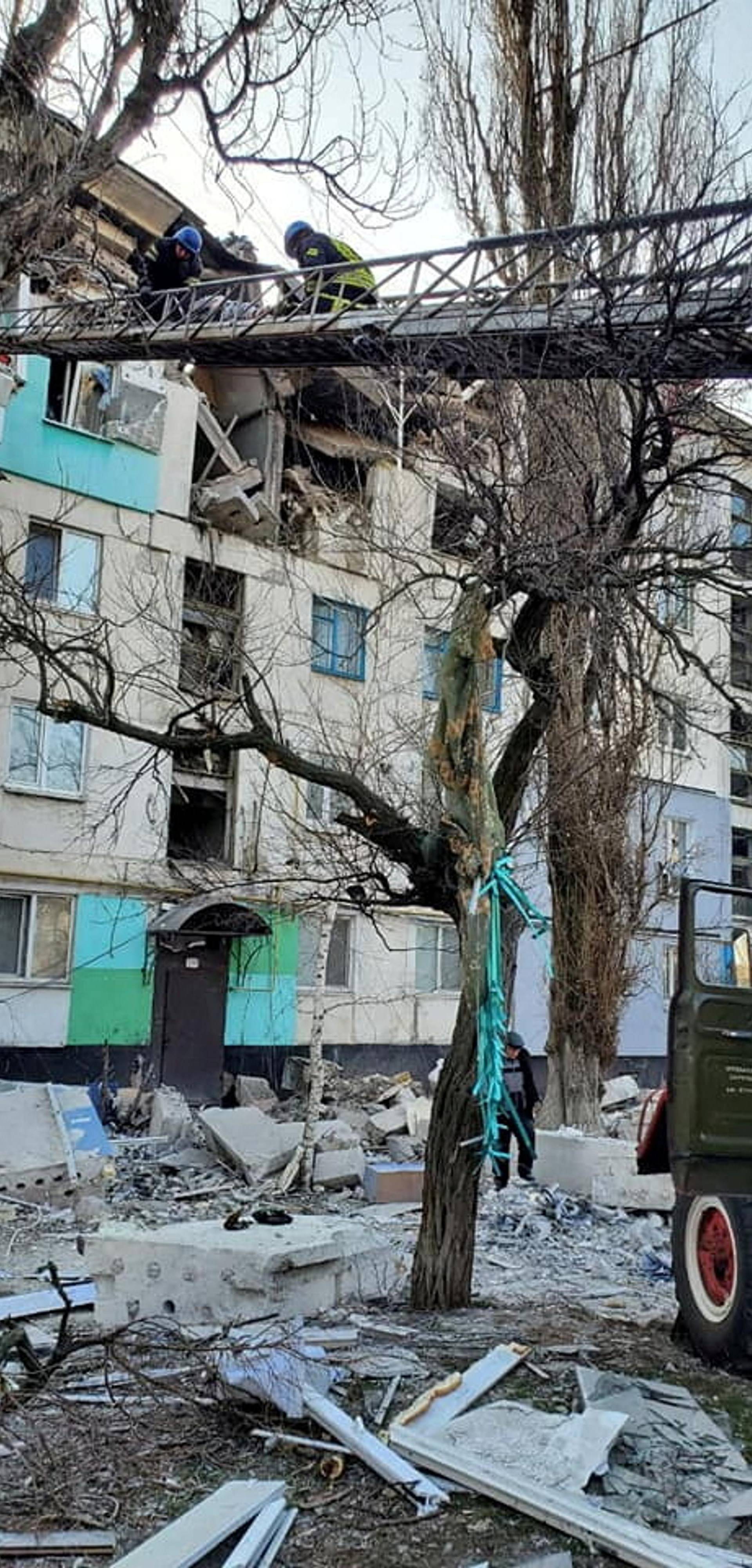 FILE PHOTO: Rescuers evacuate a person from a residential building damaged by military strike in Lysychansk