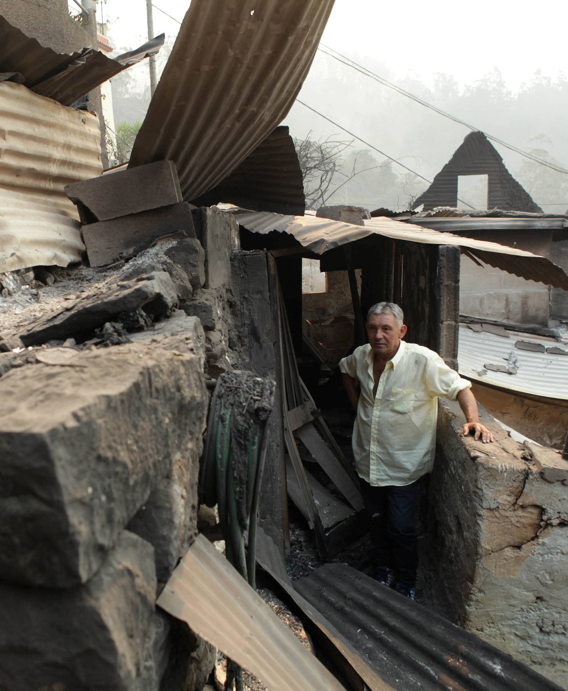 Avelino Viveiros poses for a photo after his house was burnt yesterday at Curral dos Romeiros