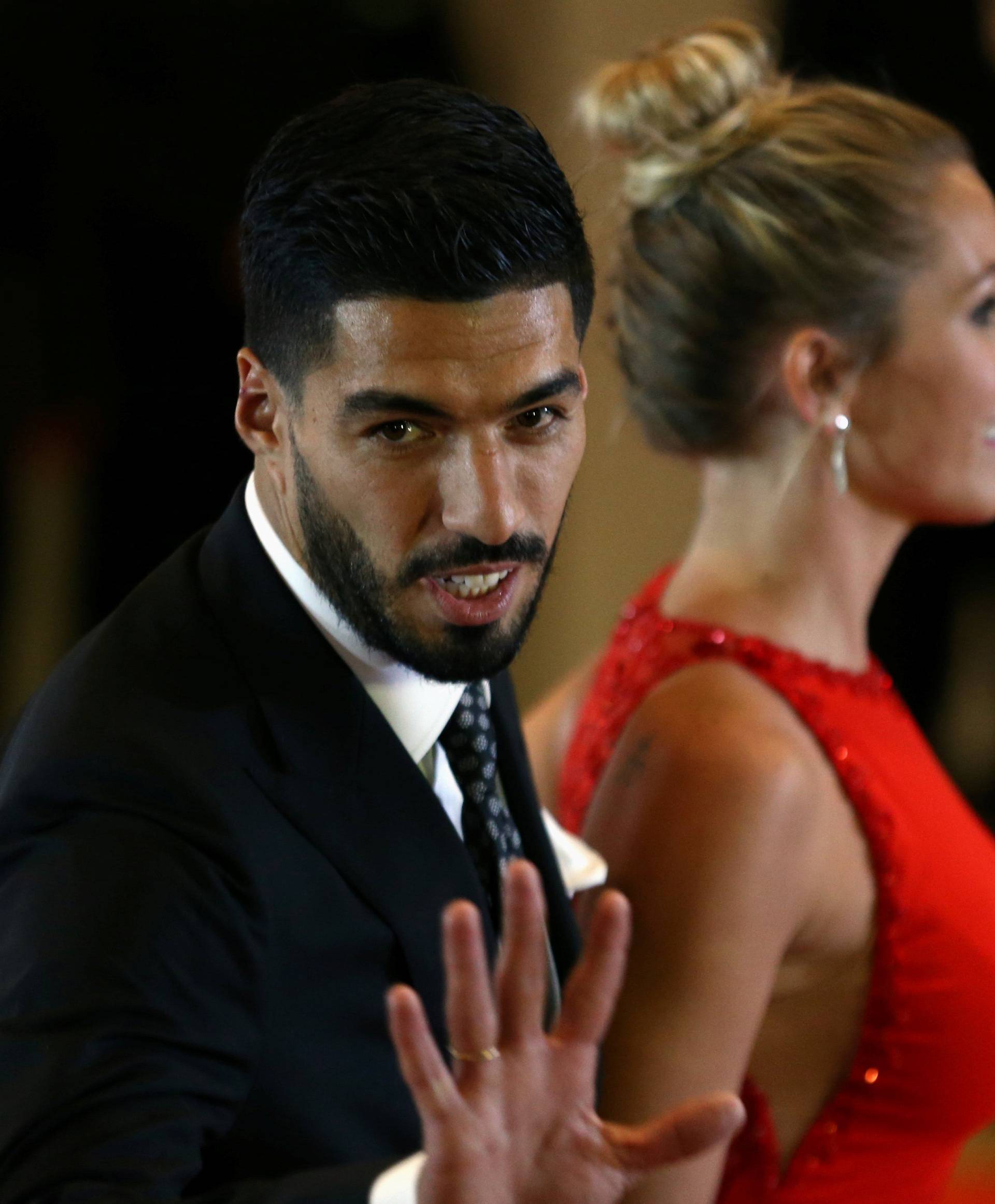 Barcelona FC's Luis Suarez, teammate of Argentine soccer player Lionel Messi, gestures next to his wife Sofia Balbi as they pose for photographers as they arrive at the wedding of Messi and Antonela Roccuzzo in Rosario
