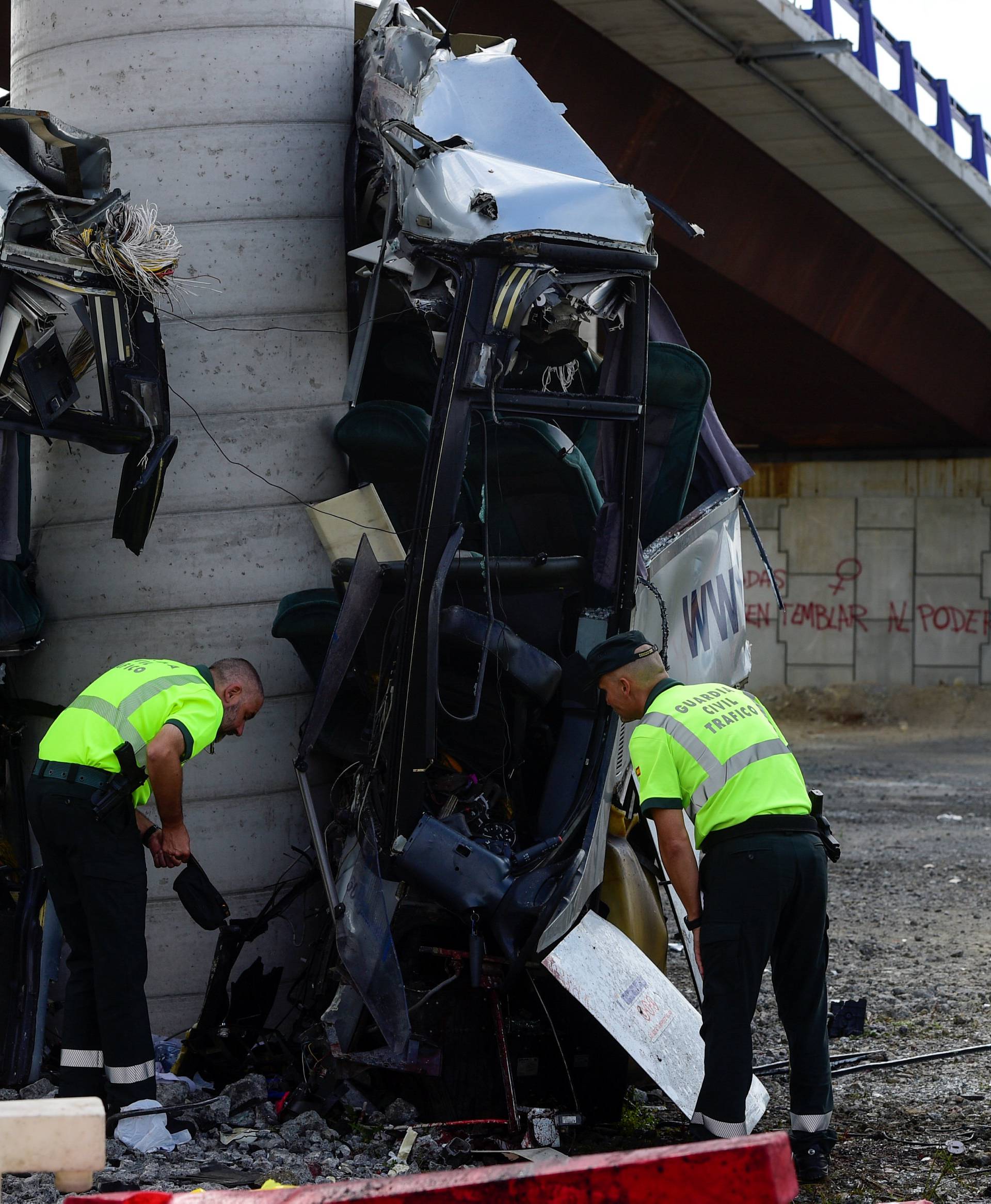 Civil guards survey the wreckage of a bus crash which left at least four people dead in Aviles