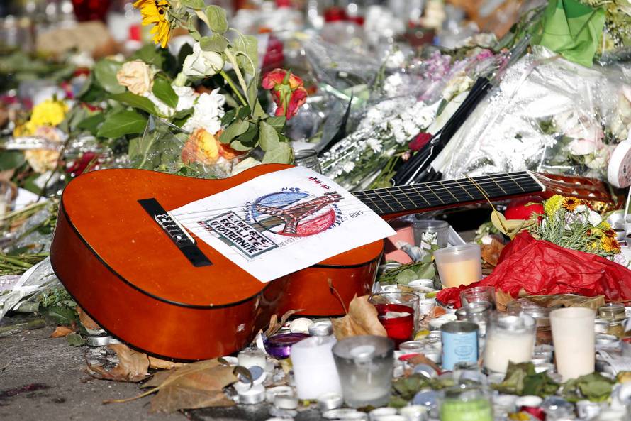 FILE PHOTO: A guitar with a message bearing France's national motto "Liberte, Egalite, Fraternite", is seen among flowers left in tribute to victims near the Bataclan concert hall, one of the sites of last Friday's deadly attacks, in Paris, France