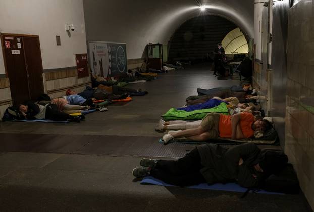 People take shelter inside a metro station during a Russian drone and missile strike in Kyiv