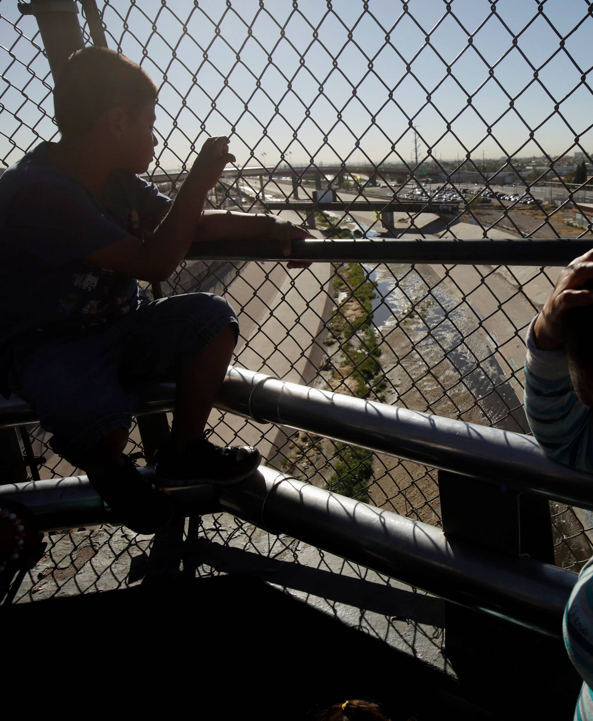 A migrant family from Mexico, fleeing from violence, wait to enter the United States to apply for asylum at Paso del Norte international border crossing bridge in Ciudad Juarez