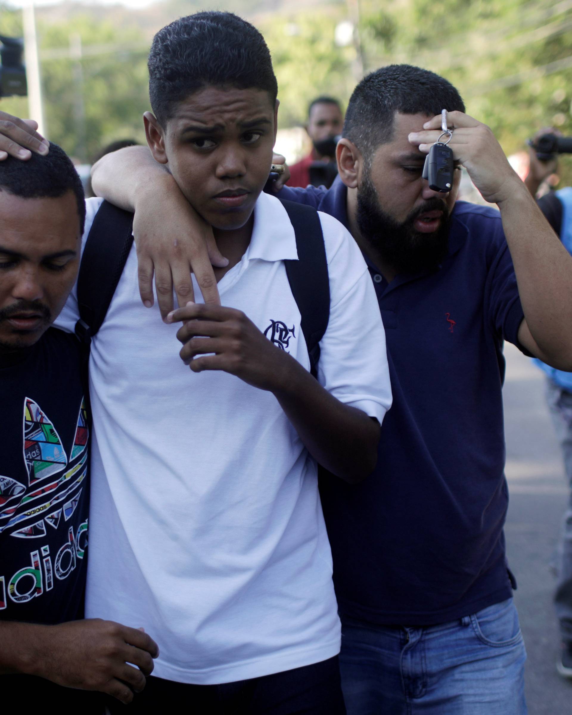 People embrace in front of Flamengo training center after deadly fire in Rio de Janeiro