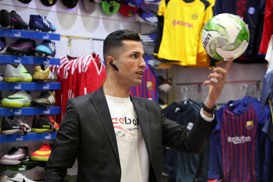Biwar Abdullah, 25, an Iraqi Kurdish local footballer, who looks like the football player Cristiano Ronaldo, pose for a pictures at a sportswear shop in the district of Soran, northeast of Erbil