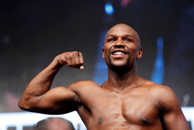 Undefeated boxer Floyd Mayweather Jr. of the U.S. poses on the scale during his official weigh-in at T-Mobile Arena in Las Vegas