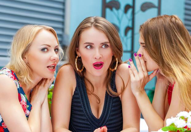 Three beautiful girlfriends gossiping woman sitting at a table i