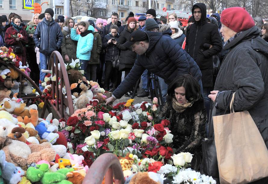 People place toys and flowers at a makeshift memorial for the victims of a shopping mall fire in Kemerovo