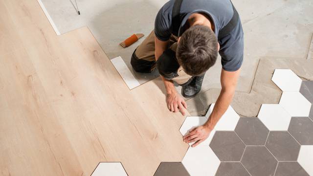 Male,Worker,Installing,New,Wooden,Laminate,Flooring.,The,Combination,Of