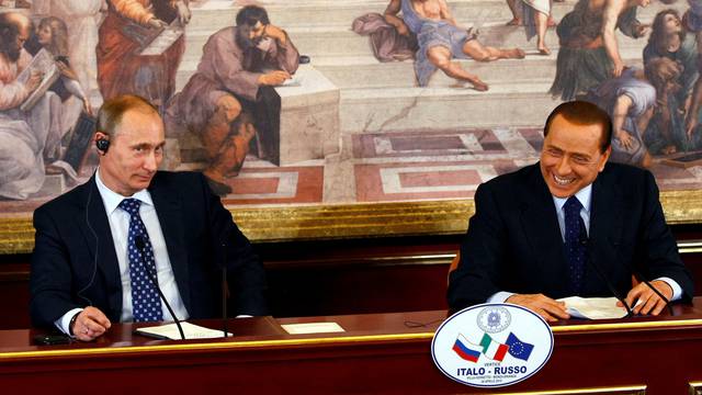 FILE PHOTO: Italian PM Berlusconi smiles as Russian PM Putin looks on during a news conference at a summit in Gerno