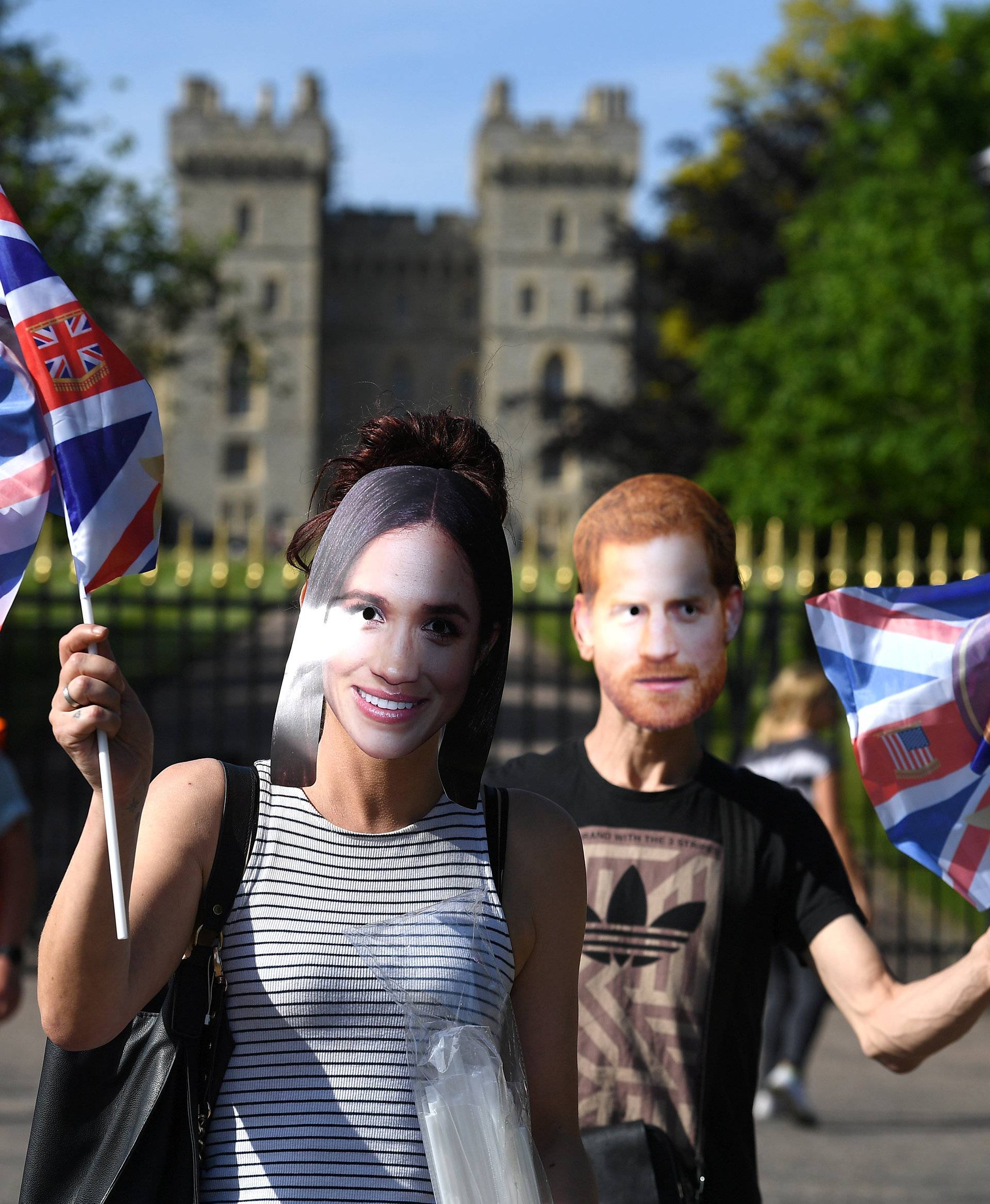 Royal fans wear masks of Britain's Prince Harry and Meghan Markle in Windsor