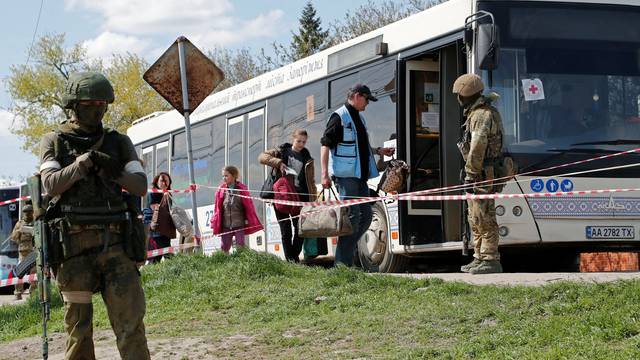 Civilians who left the area near Azovstal steel plant in Mariupol board a bus near a temporary accommodation centre in Bezimenne