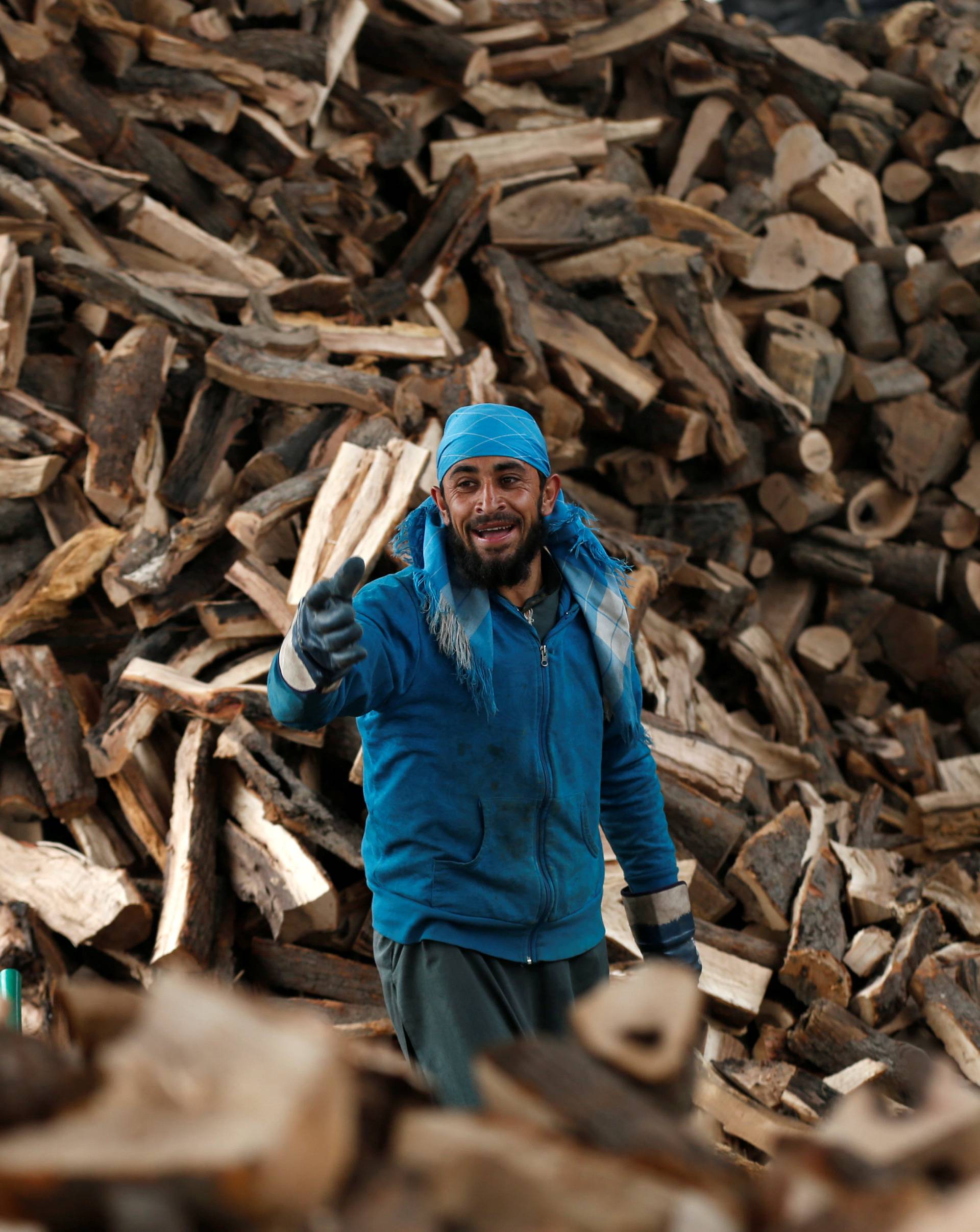 An Afghan man works at his firewood stall in Kabul, Afghanistan
