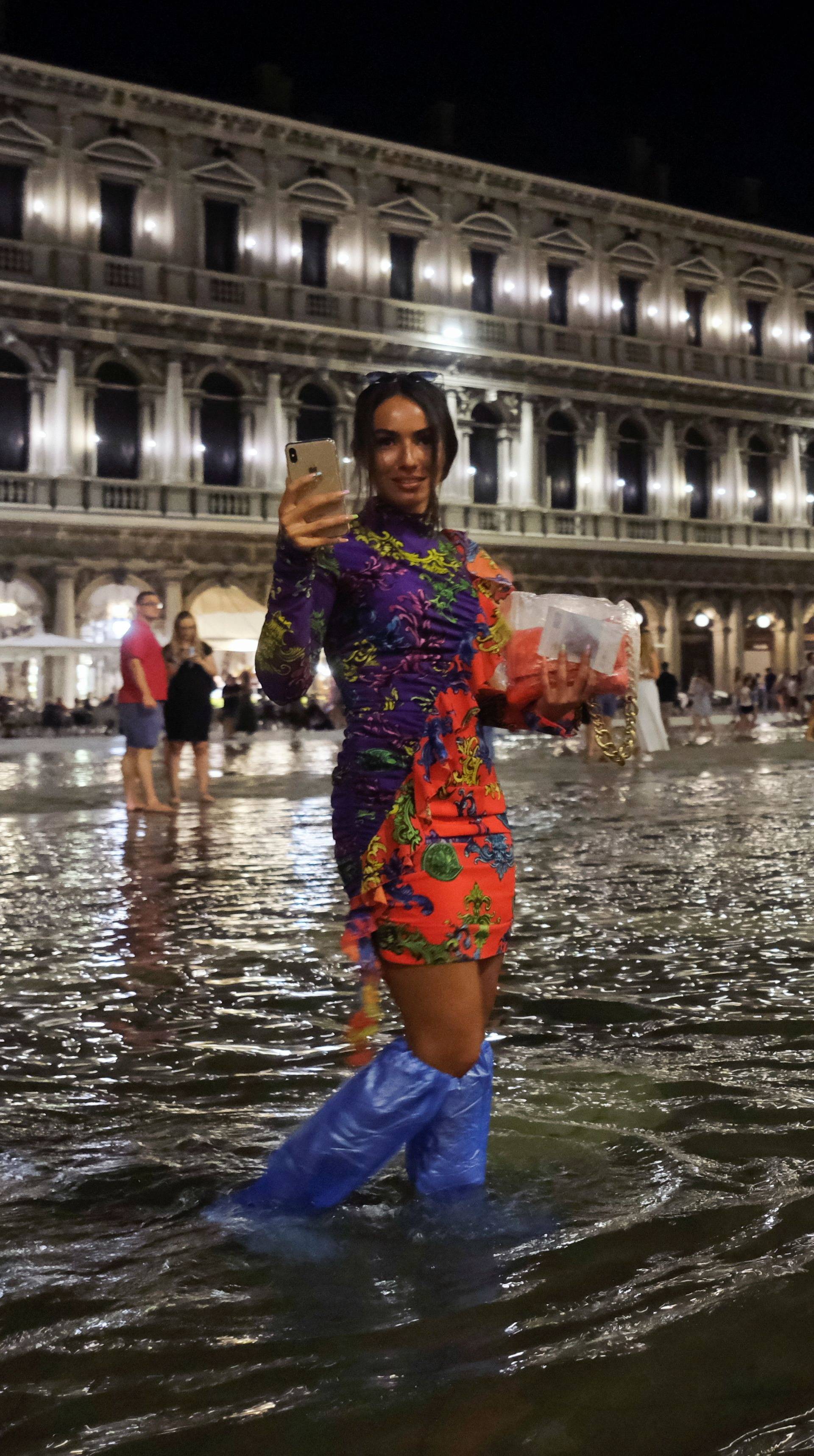 A woman walks in a flooded St. Mark's Square during an exceptional high water in Venice