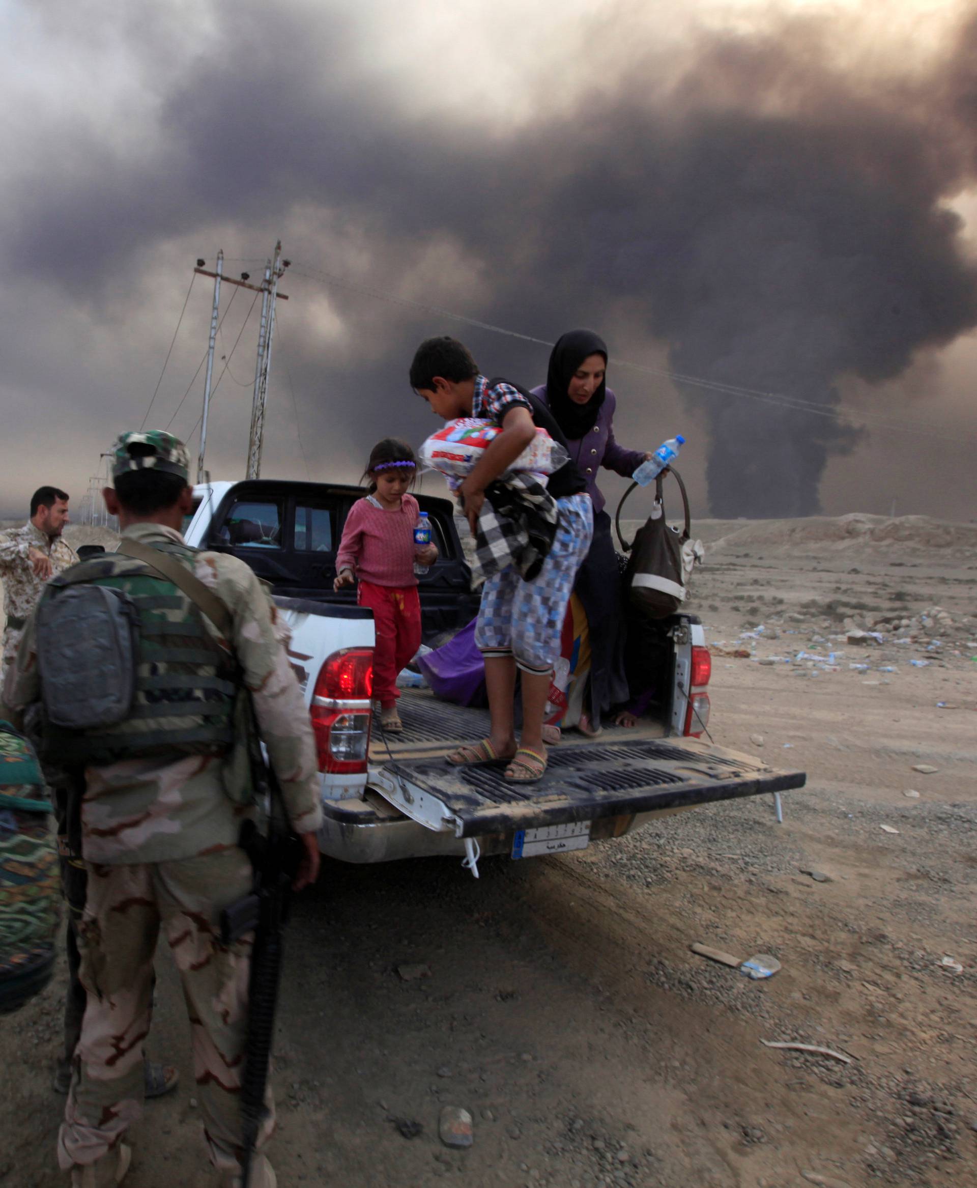 Displaced people who are fleeing from clashes arrive in Qayyarah, during an operation to attack Isla mic State militants in Mosul