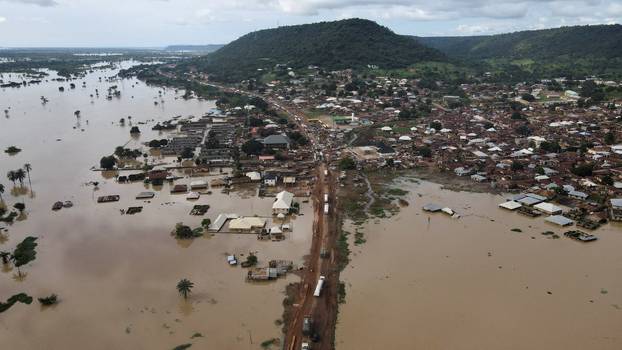 Vehicles are seen on a flooded road in Lokoja