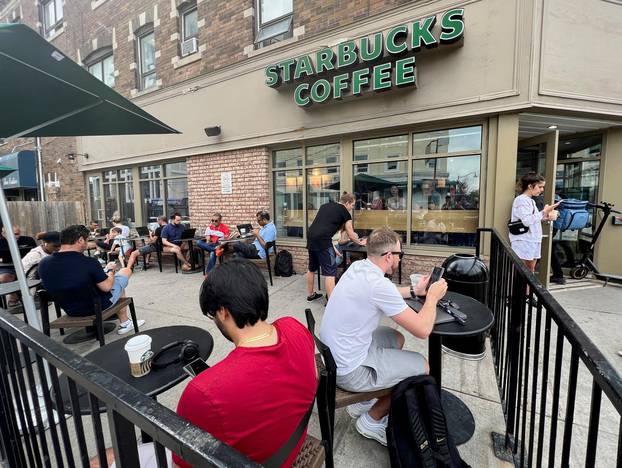 People crowd around a Starbucks coffee shop to use its free wifi