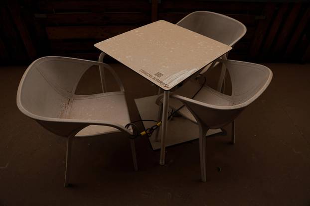 Dust covers chairs and a table at a restaurant terrace as storm Celia blew sand from the Sahara desert over Madrid