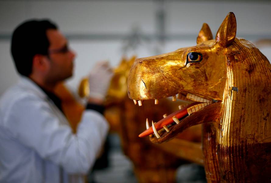 An Egyptian archaeological technician renovates a pharaonic bed with animal figures which belonged to The Golden King Tutankhamun, in the conservation centre of the Grand Egyptian Museum, on the outskirts of Cairo