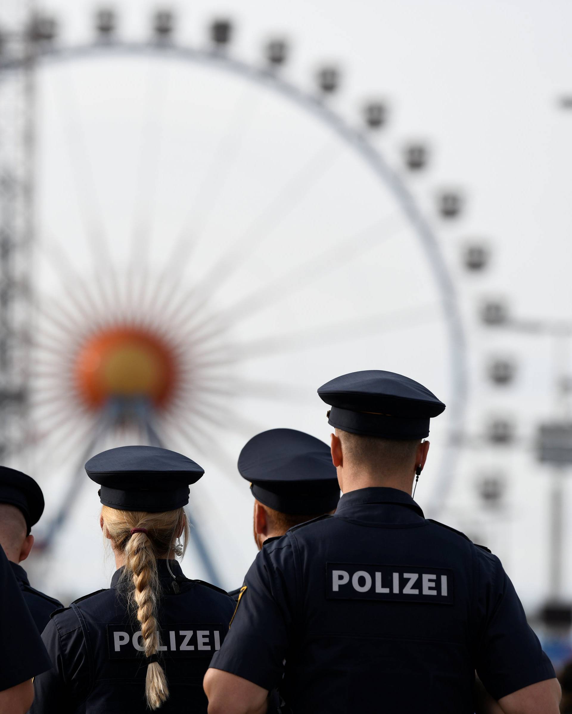 Police officers are seen standing in front of the ferris wheel during the opening day of the 185th Oktoberfest in Munich