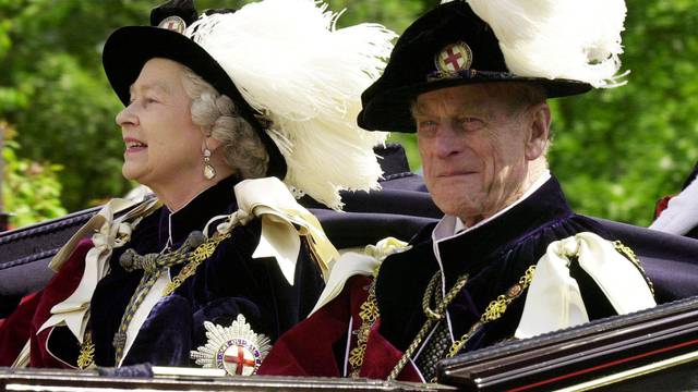 FILE PHOTO -  File photo of Britain's Queen Elizabeth II and Prince Phillip, the Duke of Edinburgh, riding in an open-topped carriage to Windsor Castle