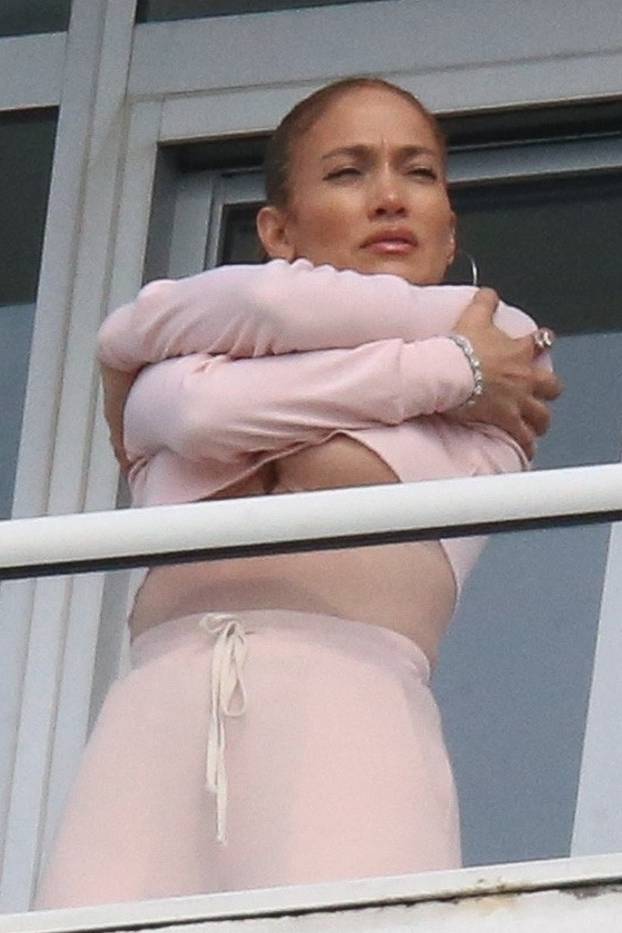 EXCLUSIVE: Jennifer Lopez flashes some serious under-boob on her hotel balcony in Miami