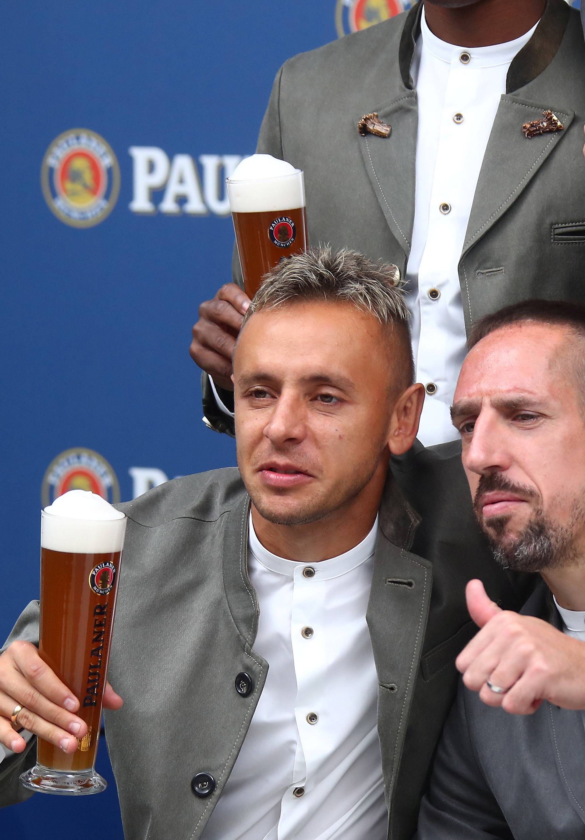 Bayern Munich's soccer team wearing traditional attire, toasts with beer during photocall in Munich