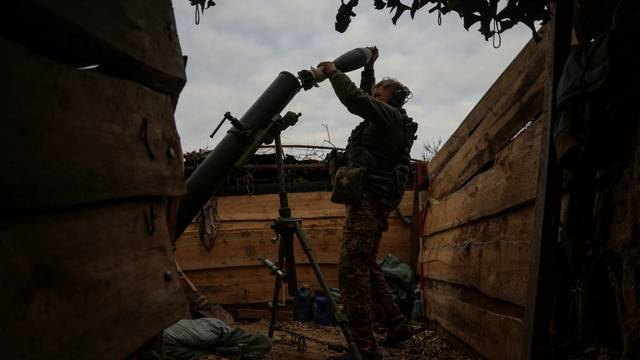 FILE PHOTO: Ukrainian serviceman loads a shell into a mortar as he fires toward Russian troops at a position near a frontline in Zaporizhzhia region