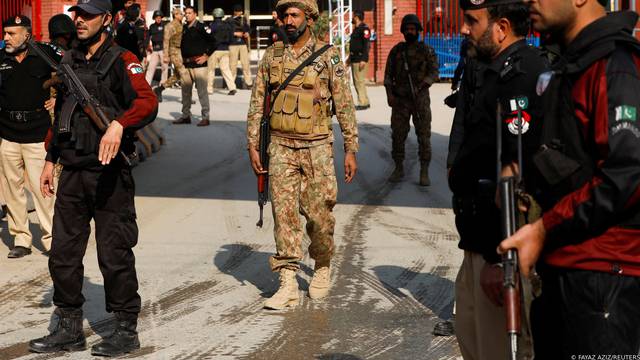 Military soldiers and police officers stand guard, after a suicide blast in a mosque in Peshawar