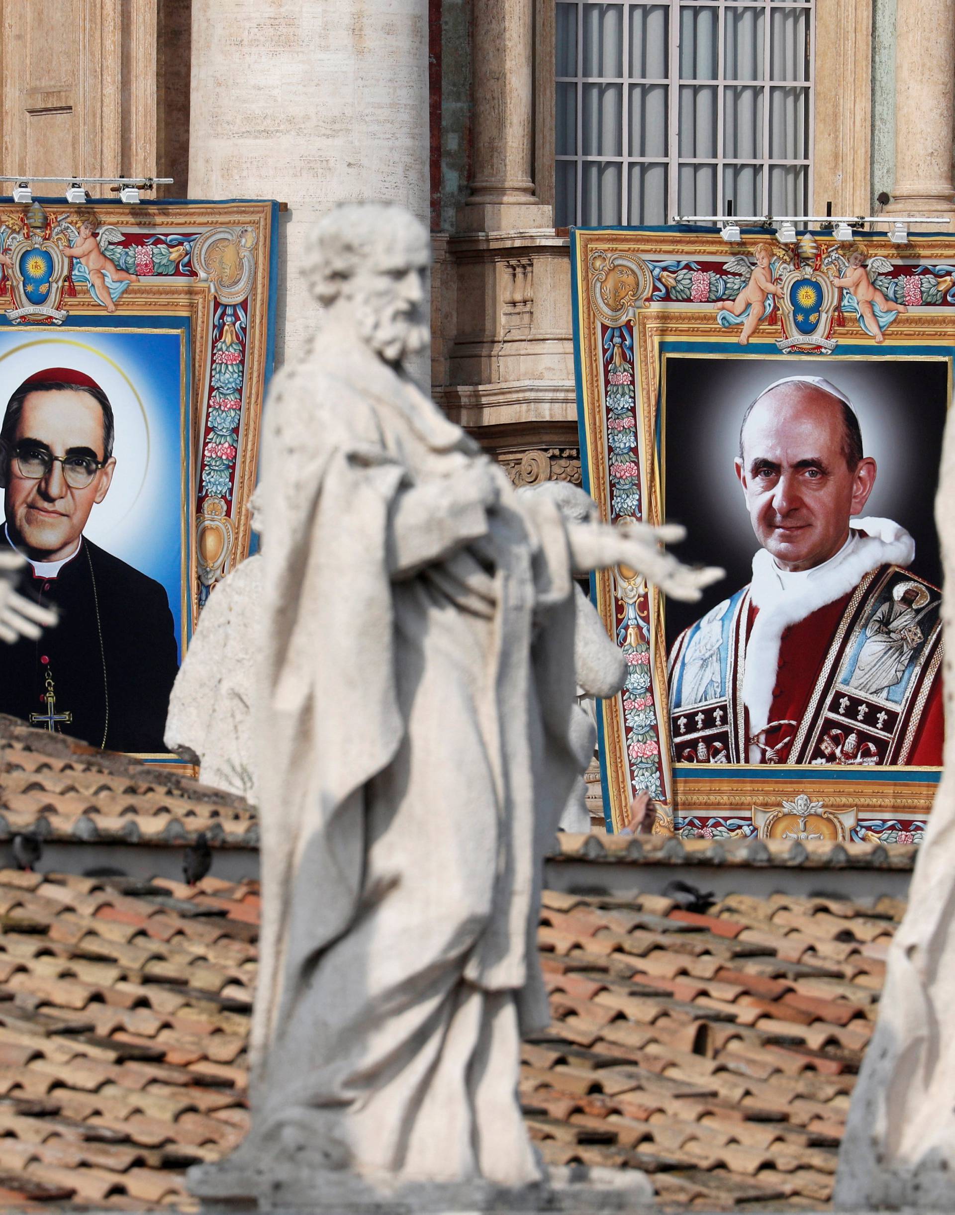 Pope Paul VI and El Salvador's Archbishop Oscar Romero pictures are seen during a Mass for their canonisation at the Vatican